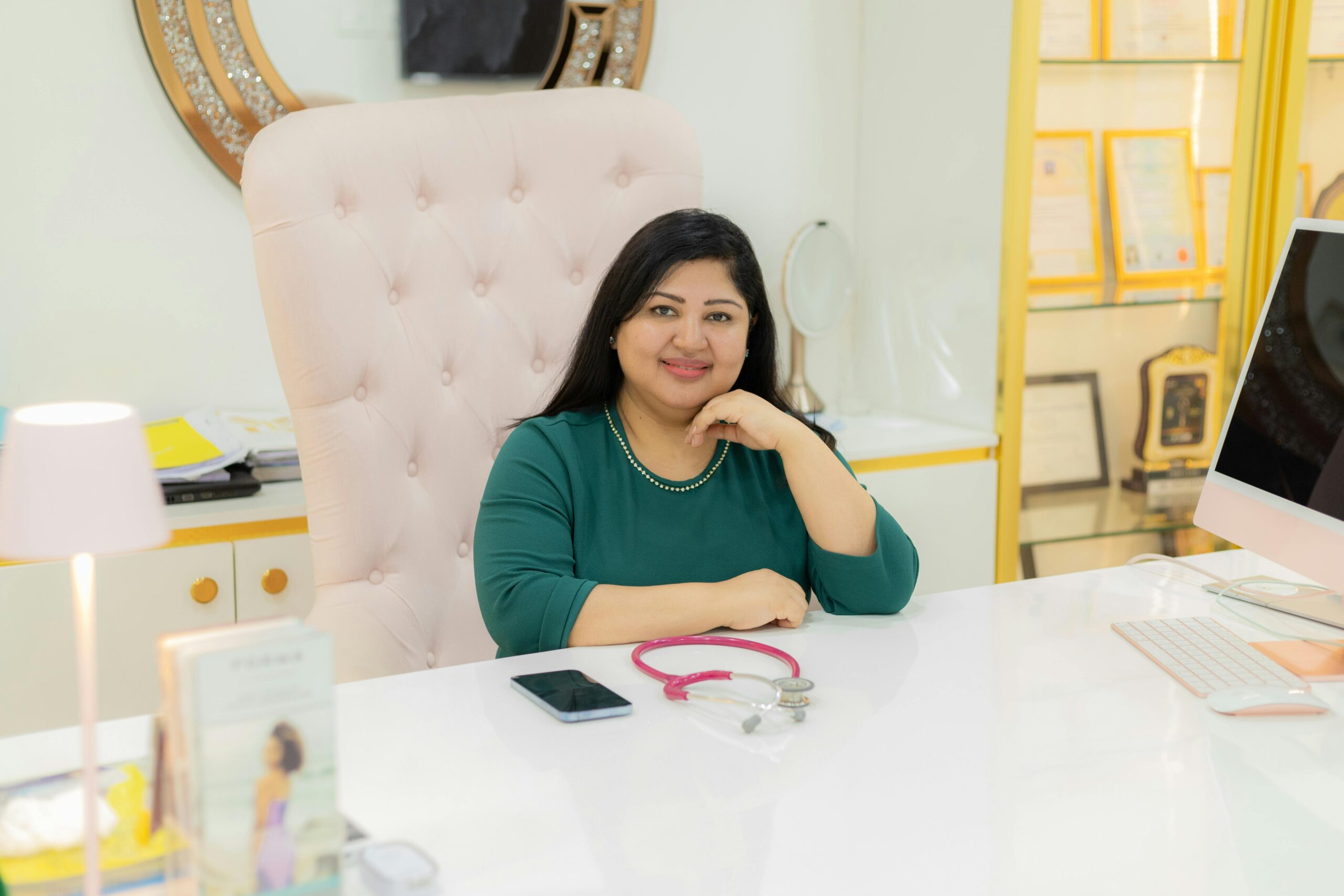 Confident woman sitting at her desk in a modern, elegant office setting.